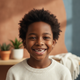 A happy child, around 8-10 years old, smiling warmly at the camera in a headshot portrait.